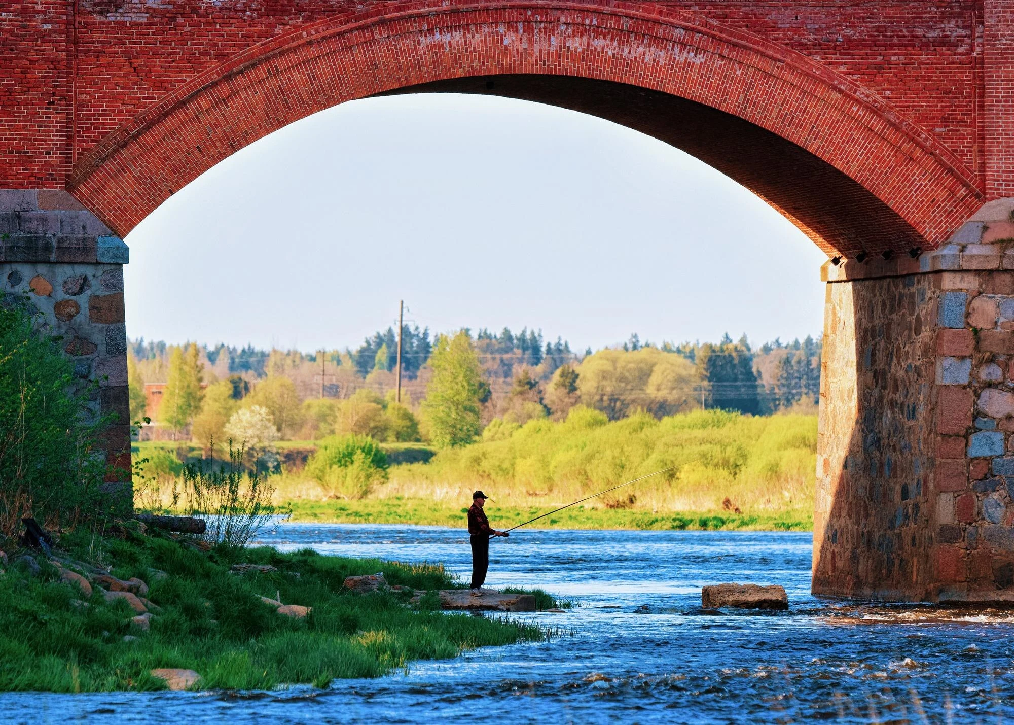 Cascada de Ventas Rumba y puente histórico de ladrillo sobre el río Venta en Kuldīga.