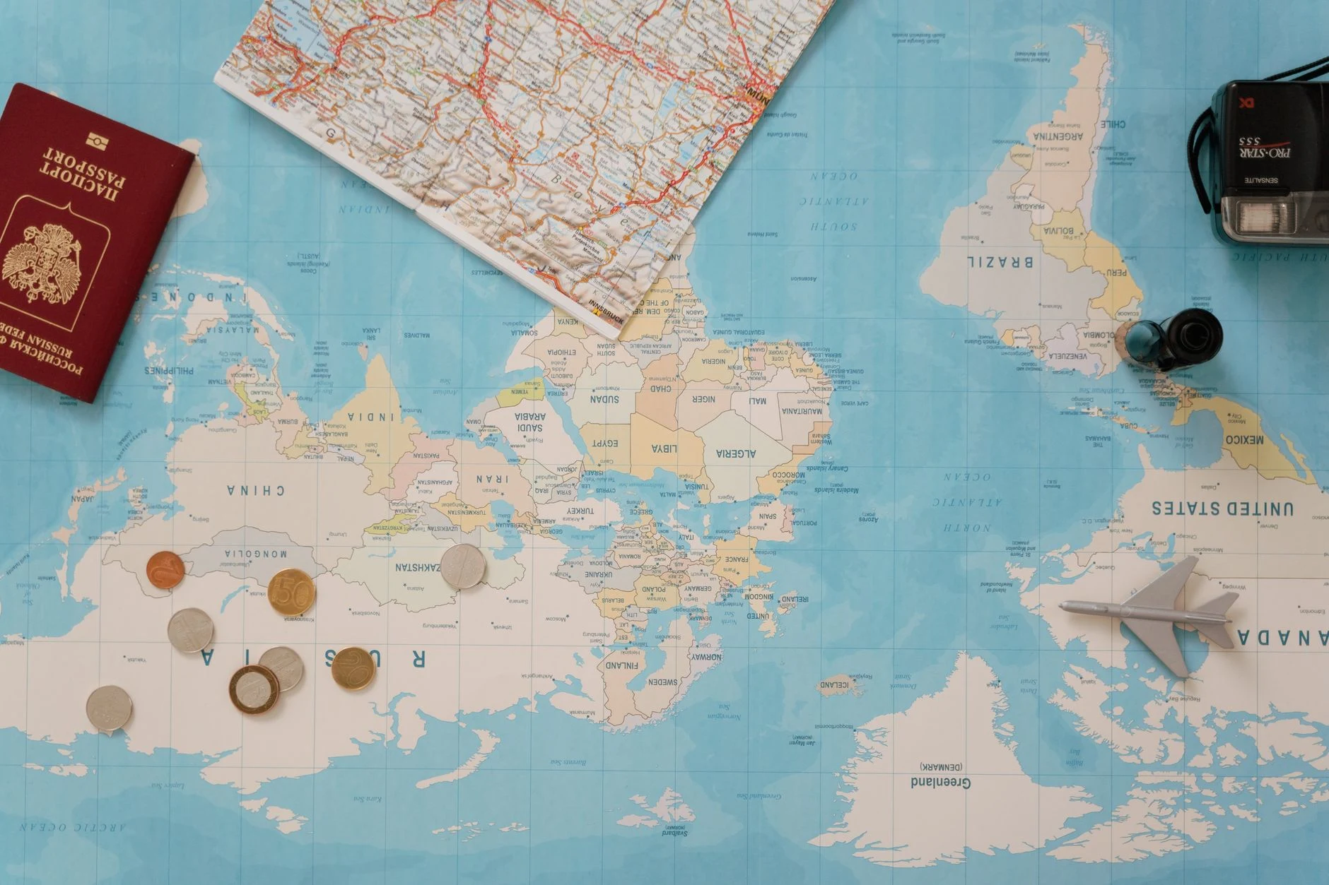 Viajera revisando un pasaporte y un mapa antes de aplazar un viaje