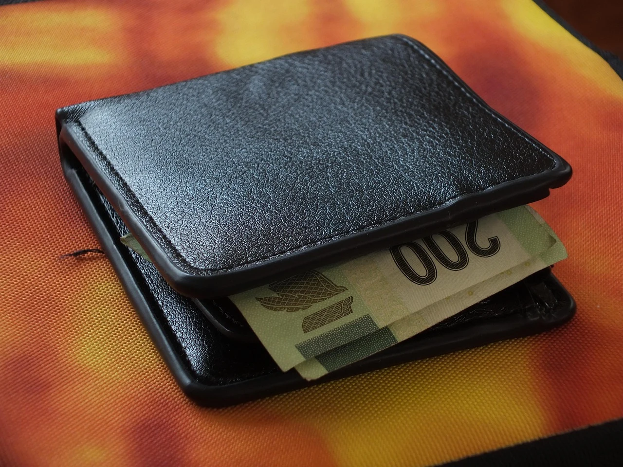 Presupuesto de viaje junto a cartera y calculadora, imagen de contexto.