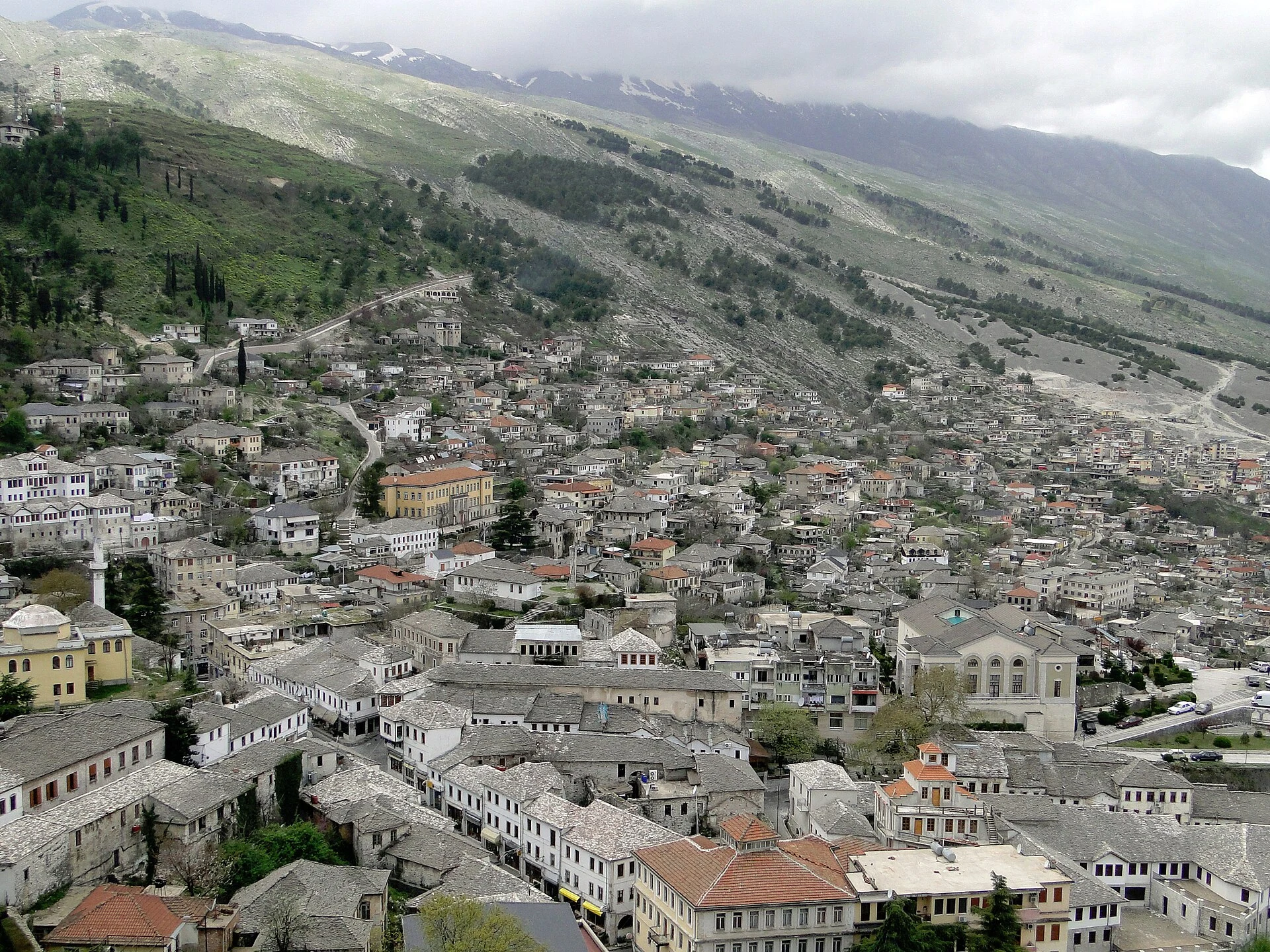 Tejados de piedra y casas históricas de Gjirokastër sobre el valle del Drino.