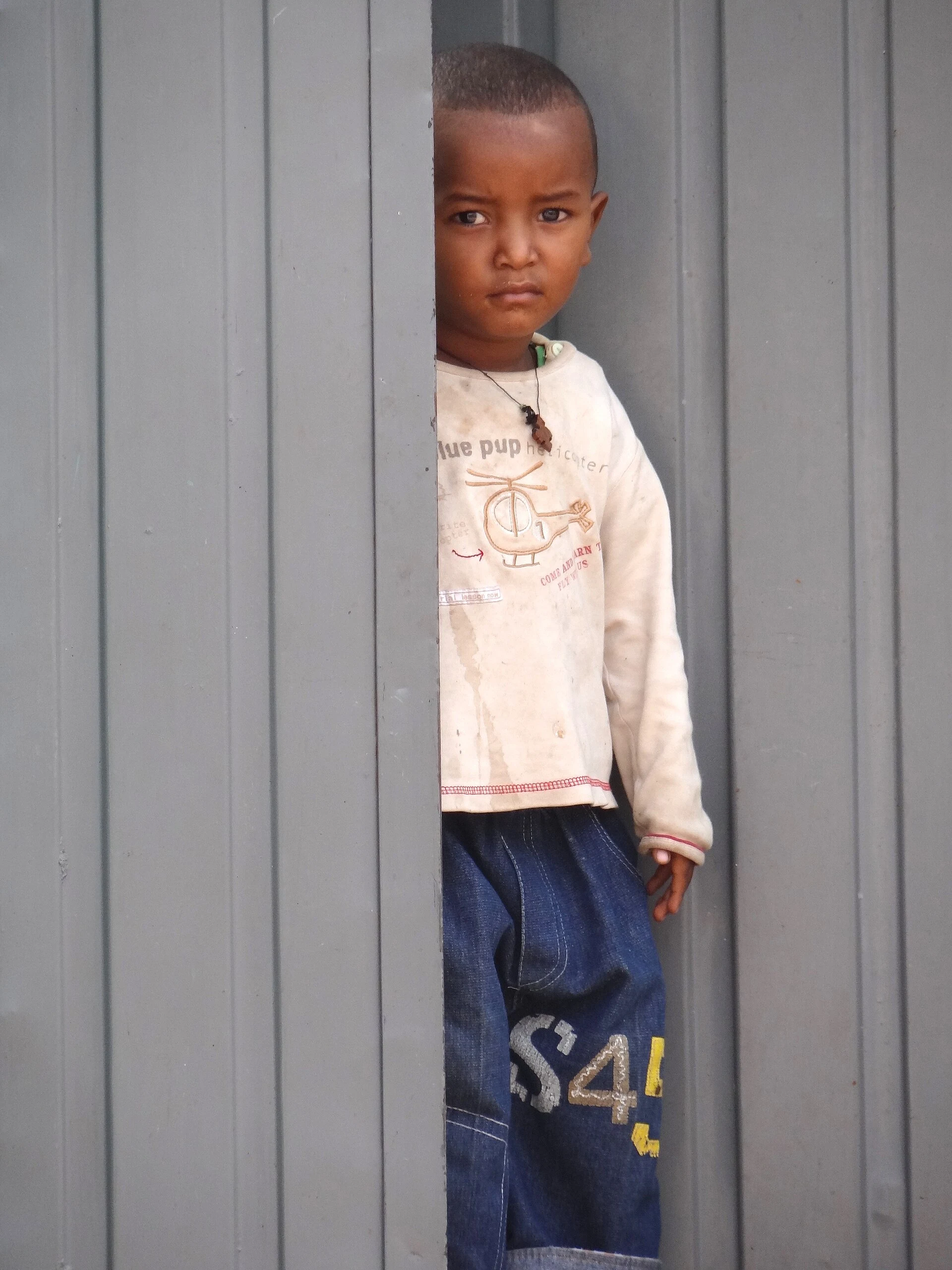 Callejón histórico de Harar Jugol con una puerta de madera y luz de mañana.