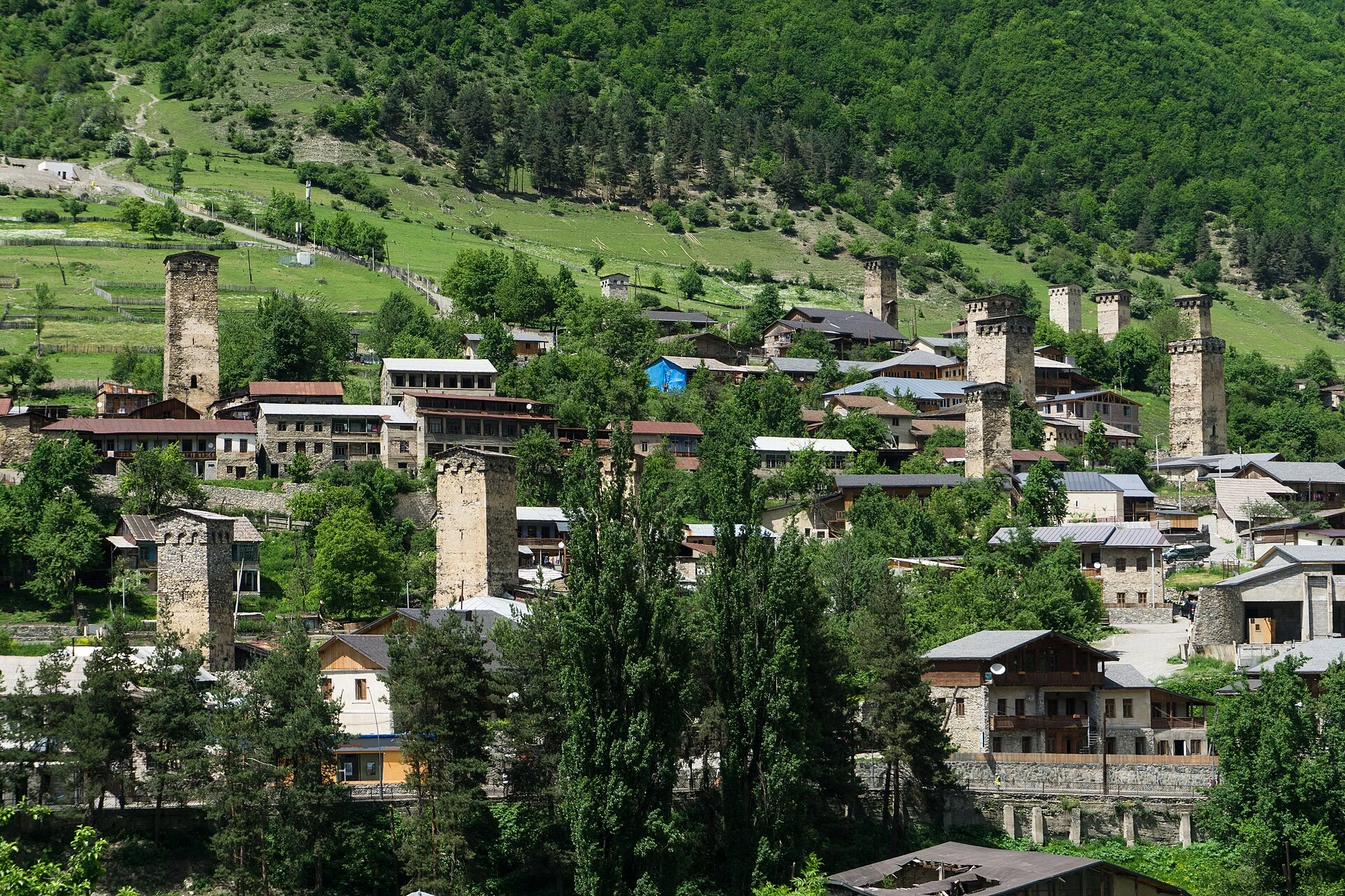 Torres svanas y casas de piedra en Mestia, con montañas del Cáucaso al fondo.