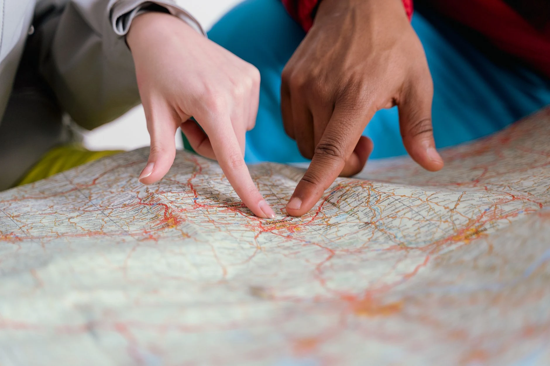Manos consultan un mapa de viaje sin mostrar una ruta concreta.