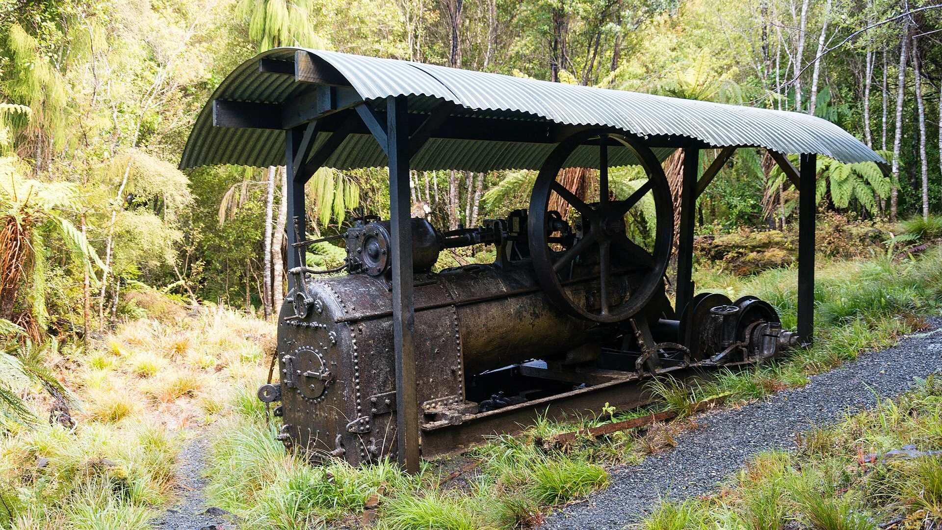 Botas de senderismo y polainas sobre un sendero boscoso y embarrado.