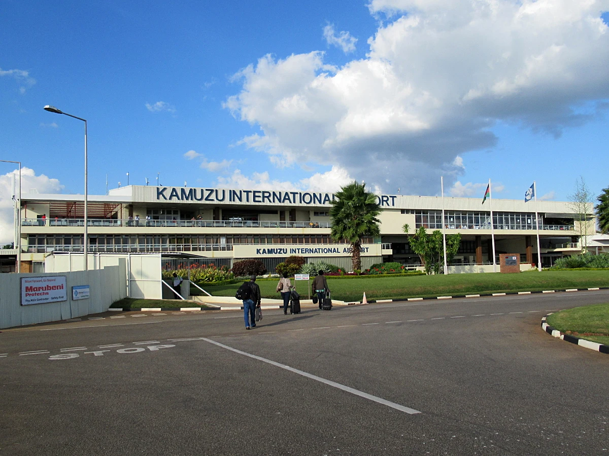 Exterior del terminal del Aeropuerto Internacional de Lilongwe con aviones al fondo.
